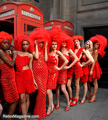 Pierre Garroudi models dressed in red posing next to the phone-box in London